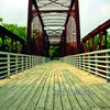 The cover of Haunted Austin, Texas by Schiffer Publishing, Ltd. shows an empty wooden and steel bridge with trees behind it, capturing the mysterious atmosphere of haunted and ghost tour Austin. The publisher’s logo appears in the lower left corner.