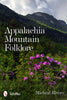 Book cover for Appalachia Mountain Folklore by Schiffer Publishing, Ltd., featuring a scenic mountain landscape with green trees, rocky cliffs, and blooming purple flowers that reflect the spirit of Appalachian folklore and ghost stories.