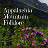 Book cover for Appalachia Mountain Folklore by Schiffer Publishing, Ltd., featuring a scenic mountain landscape with green trees, rocky cliffs, and blooming purple flowers that reflect the spirit of Appalachian folklore and ghost stories.