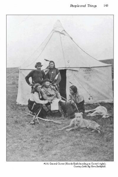 A black-and-white image from Schiffer Publishing, Ltd.'s "Fort Abraham Lincoln" shows four Indigenous men in traditional clothing by a canvas tipi on grassy land, with a dog lying in front.