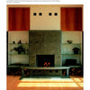 Schiffer Publishing, Ltd.'s Fireplaces features a stone-framed modern fireplace with black firebox, flanked by tall wooden cabinets and white shelves with ceramics. Stacks of firewood below add both style and function for design inspiration.