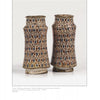 Mediterranean Maiolica by Schiffer Publishing, Ltd. features two tall, narrow cylindrical vases with flared rims, showcasing intricate brown, blue, and white geometric and floral glazed designs, set against a white background. Collectors highly value these pieces.