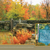 Amid autumn trees, the Dublin Town Pound—featured in "New Hampshire" by Schiffer Publishing, Ltd.—offers a striking photo spot. An inset reveals a green sign about its 18th-century role holding stray animals.