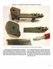 Three olive-green suspension parts and a metal X-ACTO knife are displayed on a white surface. These detailed components, for 1/6 scale Stuart tank models, are featured in "Large Scale Armor Modeling" by Schiffer Publishing, Ltd.