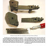 Three olive-green suspension parts and a metal X-ACTO knife are displayed on a white surface. These detailed components, for 1/6 scale Stuart tank models, are featured in "Large Scale Armor Modeling" by Schiffer Publishing, Ltd.