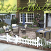 A cozy brick patio with cushioned chairs, a table, umbrella, and vibrant flowers creates charm, all framed by a white picket fence in front of a house. "Beach Boundaries" by Schiffer Publishing, Ltd. is overlaid at the top.