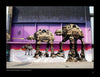 Exterior street art mural of three large AT-AT walkers as boomboxes in front of a purple-pink backdrop, inspired by UK graffiti writers and featured in "100 UK Graffiti Artists" from Schiffer Publishing, Ltd.