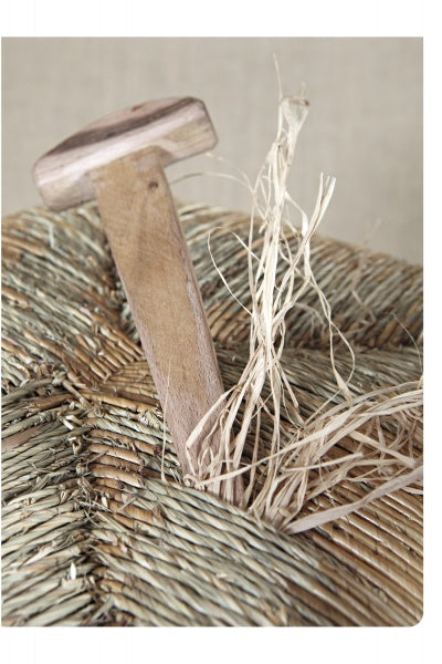 The book "Cane & Rush Seating" from Schiffer Publishing, Ltd. features a T-handled wooden tool on a woven straw seat with loose strands—capturing the essentials of rush weaving and seat restoration.