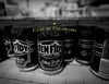 A black and white photo of Schiffer Publishing, Ltd.’s "Canned!" showcases beer cans in rows, celebrating Colorado’s craft beer scene with “Cans of Colorado” and “Colorado” text overlaid.