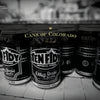 A black and white photo of Schiffer Publishing, Ltd.’s "Canned!" showcases beer cans in rows, celebrating Colorado’s craft beer scene with “Cans of Colorado” and “Colorado” text overlaid.