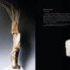 A spread from The Art of the Contemporary Doll by Schiffer Publishing, Ltd. shows text on Elisabeth Fuelle-Tornamichel and her wood sculpture on the left, and a doll of an older woman in white on a fuzzy couch on the right.