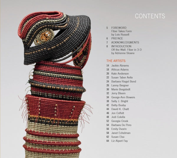 A woven fiber sculpture in black, red, and tan stands beside a contents list for "Artistry in Fiber, Vol. 2" by Schiffer Publishing, Ltd., highlighting sections and names of contemporary three-dimensional artists.