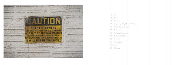 A weathered sign on a white brick wall at the Domino Sugar Refinery features in "Brooklyn's Sweet Ruin" by Schiffer Publishing, Ltd., highlighting Brooklyn photography’s glimpse into local industrial history.