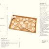 A brown tray holds assorted unfinished leather pieces and crafting tools—ideal for making unique Schiffer Publishing, Ltd. Tanned Leather Hand-Made Bags—displayed on a cream background.