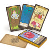 Three illustrated cards from the Dark Goddess Tarot by Schiffer Publishing, Ltd.—Strength (woman and bear), Spider Woman, and Duroa—stand behind a face-down card and a deck with a red crab, celebrating the sacred feminine.