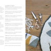 An open book, "Rug Hooking with Wool Strips" by Schiffer Publishing, Ltd., displays supplies and tips. Nearby: a floral rug, thread, scissors, hook tool, and towel—ideal inspiration for modern crafters or punch needle enthusiasts.