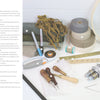 A selection of sewing and crafting tools is displayed on a white surface, perfect for modern projects like "Rug Hooking with Wool Strips" by Schiffer Publishing, Ltd.