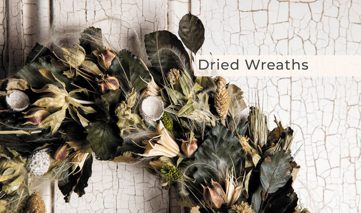 A close-up of a dried Schiffer Publishing, Ltd. Wreaths made of leaves, seed pods, and grasses, set against a white rustic background. "Wreaths" is overlaid in the upper right corner, ideal for contemporary decor lovers.