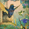 A mystical hummingbird with ornate patterns hovers by a gold-framed window and blue flowers, accompanied by another green hummingbird. From Hummingbird Wisdom Oracle Cards by Schiffer Publishing, Ltd: call on Siwar Q’ente for courage and growth.