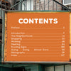 An orange sign outside a NYC brick building, resembling vintage advertising, displays a table of contents—an image featured in "Ghost Signs 2" by Schiffer Publishing, Ltd., inspired by the city’s historic ghost signs.