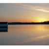 A tranquil lake at sunset near a boathouse captures Maryland's Eastern Shore, featured in "Maryland's Eastern Shore" by Schiffer Publishing, Ltd., highlighting the beauty of Blackwater National Wildlife Refuge.