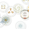 Schiffer Publishing, Ltd.’s Transparent Oracle features see-through, circular cards with intricate, abstract line art of plants, animals, and geometric shapes in vibrant colors. Each numbered card is scattered on a white background for easy reference.