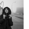 Coney Island People" by Schiffer Publishing, Ltd. features striking black-and-white photos of a woman in a hooded coat by a roller coaster and a man in a tank top, inspired by classic Coney Island street photography.