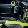 The interior featured in "Air & Water" by Schiffer Publishing, Ltd. evokes rare Porsche cars: black leather and suede seats, yellow center console, manual gear shift, and a modern dashboard with illuminated controls.