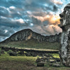 Monumental" by Schiffer Publishing, Ltd. features a massive stone moai statue on Easter Island, standing on grassy land with a mountain and dramatic, cloudy sky in the background.