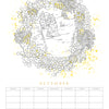 The Paint-Your-Own Wall Calendar by Schiffer Publishing, Ltd. features a hand-drawn December page with snowy landscape, pine trees, pinecones, berries in a wreath, yellow splatter accents, and a blank watercolor calendar grid—paint your own!.