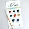 A sheet from Schiffer Publishing, Ltd.’s Paint-Your-Own Wall Calendar shows nine named watercolor swatches in various colors and a paintbrush—great inspiration for personalizing your own calendar.