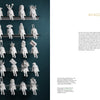 Rows of small white figurines inspired by Contemporary Black American Ceramic Artists from Schiffer Publishing, Ltd. sit on black shelves against a dark teal wall, each with unique headpieces and legs hanging over the edge. Text appears on the right.