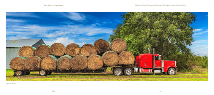 Captured by David Skernick, "Back Roads of the Midwest" from Schiffer Publishing, Ltd. features a bright red semi-truck with hay bales on a flatbed trailer, parked on grass near a barn and green tree beneath a blue sky.
