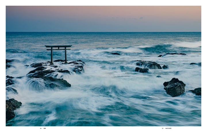 Experience serene Japanese beauty with "Japan" by Schiffer Publishing, Ltd.—a photography book featuring a torii gate rising from rocky outcrops amid gentle waves and a pastel sky, capturing the essence of dawn or dusk.
