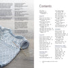 A light blue and white fair isle baby dress, inspired by KlompeLompe patterns, lies beside the table of contents from "All-Year-Round Knitting for Little Sweethearts" by Schiffer Publishing, Ltd., with two knitting needles on a wooden surface.