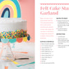 A white frosted cake topped with a rainbow decor sits on a glass stand, with a rainbow felt garland made using Schiffer Publishing, Ltd.'s Easy Cricut® Crafts guide and SVG files shown for Cricut machine projects on the right.