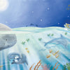 In "If I Were the Moon" by Schiffer Publishing, Ltd., a child drifts at night in a small boat beneath a full moon, surrounded by dolphins, sea otters, and vibrant coral, creating a serene bedtime scene perfect for young readers.