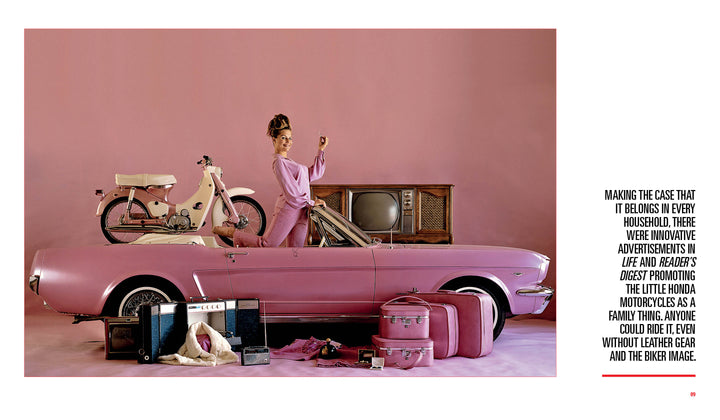 A woman in retro attire poses with a pink bicycle and the Mini Honda by Schiffer Publishing, Ltd. on a pink convertible, surrounded by vintage luggage and household items, against a vibrant pink background.