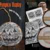 Two tree slices painted with jack-o’-lantern faces, alongside blank wood slices and templates, showcase the "How to Haunt Your House Halloween Craft Fun" kit by Schiffer Publishing, Ltd.—perfect for crafting festive Halloween party decorations.