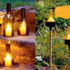 In Artfully Transforming Bottles & Plates by Schiffer Publishing, Ltd., cut wine bottles become elegant outdoor lanterns when placed on stone steps or garden stakes—perfect examples of creative glass bottle upcycling.