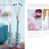 The book "Artfully Transforming Bottles & Plates" by Schiffer Publishing, Ltd. shows how to upcycle glass bottles into modern striped vases using masking tape and spray paint—perfect for creative DIY projects.