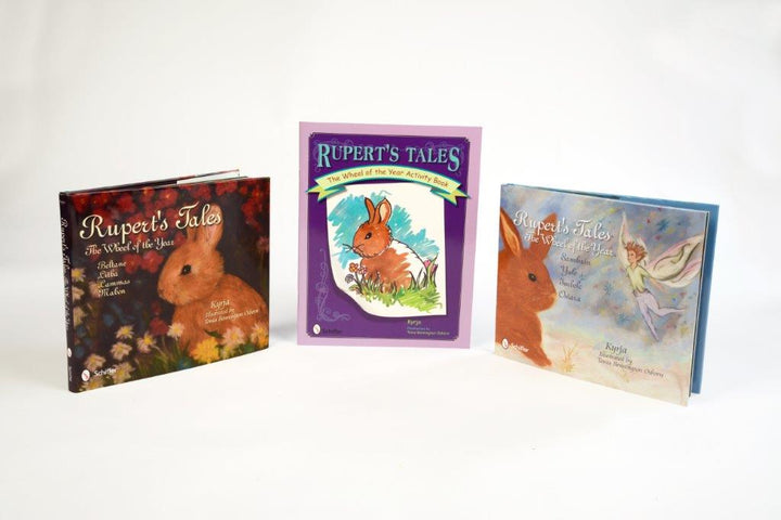 The KIDS WICCAN AND PAGAN STARTER PACK by Schiffer Publishing includes three enchanting, colorful books—two with a whimsical rabbit and one with fairies and a rabbit—perfect for introducing children to magical tales.
